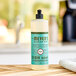 A bottle of Mrs. Meyer's Basil Scented dish soap on a counter.