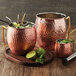 a group of copper mugs with a drink in it