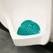 A urinal with a green circle Lavex Pine Scent Deodorized Urinal Screen in it.