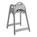 A gray unassembled high chair with a simple, modern design and safety straps.