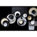 A group of Tuxton Zion matte black china plates on a black surface.