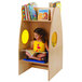 A young girl sitting in a Whitney Brothers wood bookcase reading a book.