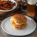 A Carlisle Griege Melamine salad plate with a hamburger and fries on it.