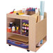 A Whitney Brothers wooden rolling art cart filled with art supplies.