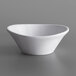 A Carlisle white melamine sauce cup on a gray surface.