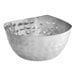 A close-up of a round stainless steel snack bowl with a hammered design and curved edge.