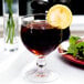 An Anchor Hocking Hoffman House schooner glass of brown liquid with ice and a lemon slice.