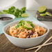 A white Carlisle melamine bowl filled with noodles, shrimp, and vegetables.