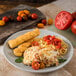 A Carlisle cement melamine dinner plate with chicken and pasta on a table.