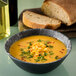 a bowl of soup with corn and green onions