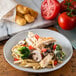 A Carlisle Ridge cement melamine salad plate with pasta, chicken, and vegetables.