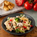 A Carlisle slate melamine salad plate with a plate of pasta with vegetables and meat.