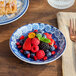 An American Metalcraft blue and white floral melamine bowl filled with berries on a table.