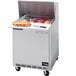 A Beverage-Air stainless steel refrigerated sandwich prep table with a sandwich on the cutting board.