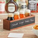 An Acopa wooden flight crate with milk bottles of brown liquid in it.