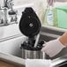 A person using a Carlisle Sparta coffee urn brush to clean a sink in a professional kitchen.