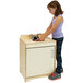 A little girl standing in front of a Whitney Brothers natural wood play sink.