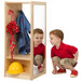 A young boy looking at himself in a mirror while wearing a yellow hard hat.