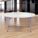 A gray NPS round folding table with metal legs.