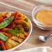 A bowl of vegetables with a spoon and Lawry's Seasoned Salt on a table.