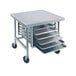 A stainless steel mobile mixer table with galvanized tray slides holding metal trays.