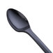 A close-up of a black WNA Comet tasting spoon.