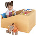 A girl sitting in a Whitney Brothers wooden quiet space with stuffed animals.