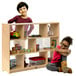 A boy and girl sitting inside a Whitney Brothers School-Age Storage Cabinet with toys.