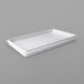 A white rectangular lid on a white tray.