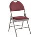 A burgundy Flash Furniture metal folding chair with a red padded seat.