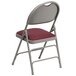 A Flash Furniture metal folding chair with a burgundy padded seat.