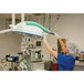 A green microfiber dusting sleeve being used to clean medical equipment in a hospital setting.