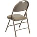 A beige metal folding chair with a padded tan seat.