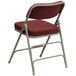 A burgundy Flash Furniture metal folding chair with a padded fabric seat.