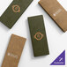A set of rectangular, textured menu covers in brown and green, each featuring customizable logos on the front.