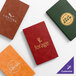 A set of four customizable menu covers in different colors, each featuring a unique logo and design.