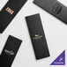 A white rectangular Menu Solutions Slim Line 4 View Menu Cover with black leather trim and gold foil on the front.