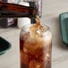 A Reading Soda Works Cola bottle pouring soda into a glass with ice.
