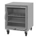 A gray Beverage-Air undercounter refrigerator with glass door and shelves on wheels.