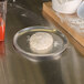 A dough being prepared on an American Metalcraft aluminum pizza pan.