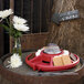 A red Sterno s'mores tray on a table with marshmallows and chocolate.