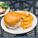 A Carlisle bone melamine plate with food on a table.