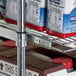 A Regency chrome wire sliding shelf holding food items.