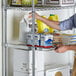 A man putting food on a Regency chrome wire sliding shelf.