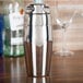 A Vollrath stainless steel cobbler cocktail shaker on a table.