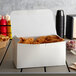 A white take-out lunch box of fried chicken on a table.