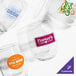A group of Acopa customizable stemless wine glasses with different logos on a table.