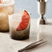 Two Arcoroc grey old fashioned glasses with ice and grapefruit slices on a marble table.