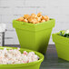 A lime green Tablecraft square condiment bowl with food in it on a table.