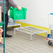 A man in a warehouse using a Regency aluminum dunnage rack to hold a green cart.